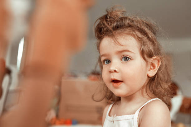 Father playing with his little daughter with finger puppets inside the house