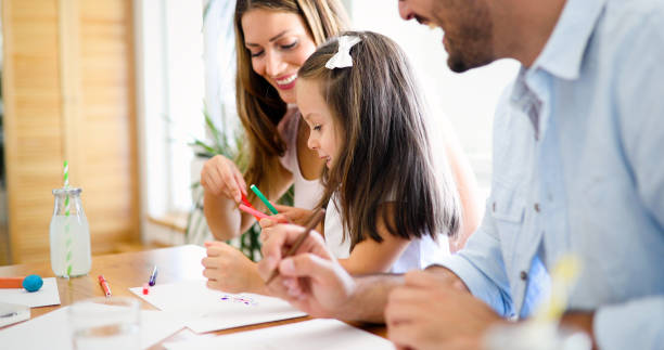 istock Mother and father drawing together with their child 1168751254