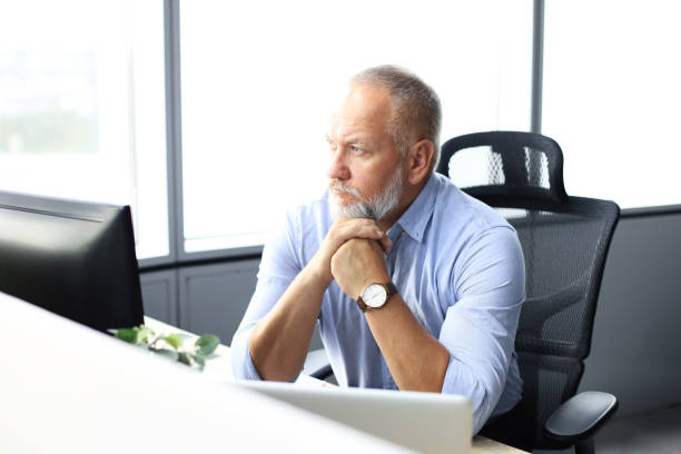 istock Focused mature businessman deep in thought while sitting at a table in modern office. 1168752212