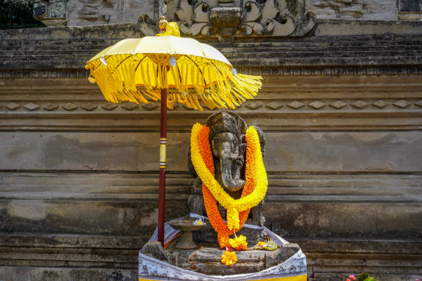 wielka statua ganeshy z żółtymi kwiatami naszyjnik i parasol - bali balinese culture art carving zdjęcia i obrazy z banku zdjęć