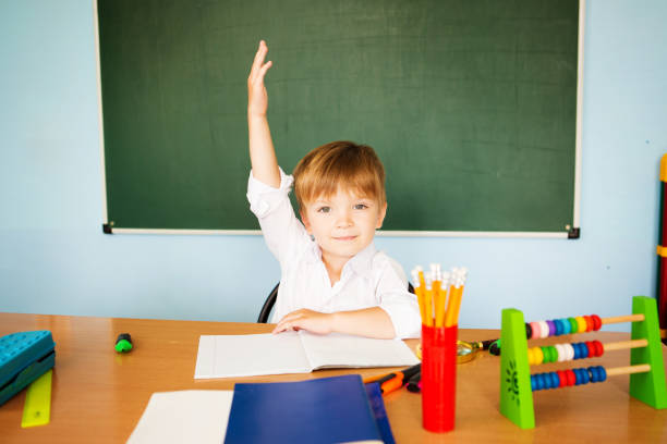 istock Back to school concept. Cheerful Schoolboy ready to answer question 1168754714