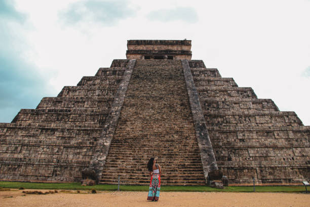 Girl standing at Kukulkan pyramid in Chichen Itza New seven wonders of the world Kukulkan pyramid in ancient city of Chichen Itza, Yucatan, Mexico kukulkan pyramid photos stock pictures, royalty-free photos & images