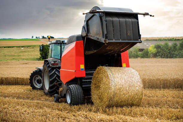 трактор и его прицеп, чтобы нажать соломинку - bale hay field stack стоковые фото и из�ображения