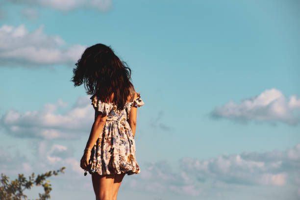 istock girl looking to the clear blue sky 1168760293