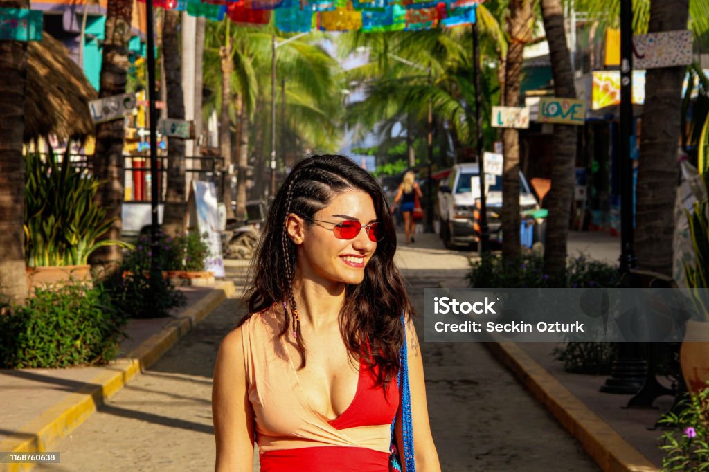 Colorful street with palm trees in Sayulita, Mexico red dressed woman at the street with colorful flags and palm trees in Sayulita, Mexico Sayulita Stock Photo