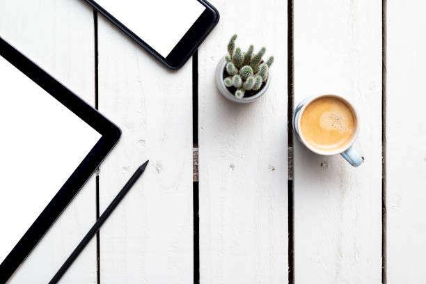 istock Office objects, devices with blank screens. White screen on smartphone and tablet on wooden table 1168762054