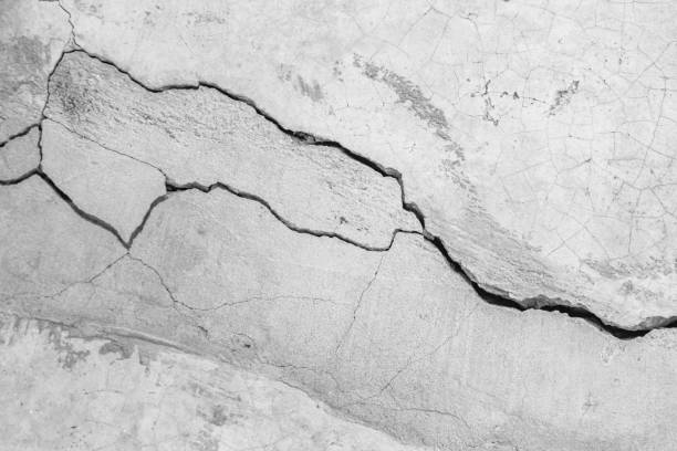 istock Grunge concrete wall at covered with gray cement old surface with crack in industrial building, great for your design and texture background. Black and white cracked floor texture vintage. 1168763062