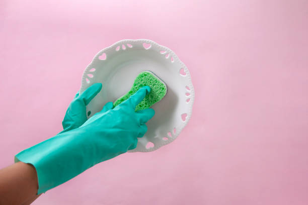 istock Hands in green protective gloves washing a plate 1168763787