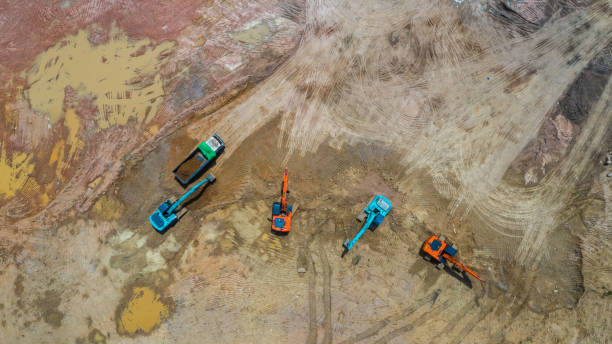 группа воздушного вида экскаватора, работающего на строительной площадке. - reclaimed land стоковые фото и изображения