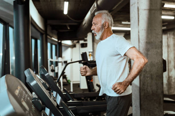 Senior man on a treadmill in a gym ruining Senior man on a treadmill enjoin run in a gym active disruptagingcollection stock pictures, royalty-free photos & images