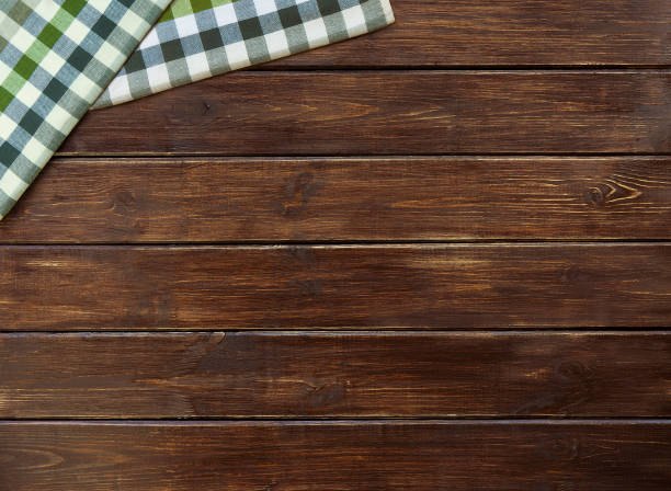 istock Two checkered cloth napkin on a brown wooden table from boards. Top view with copy space. 1168765899