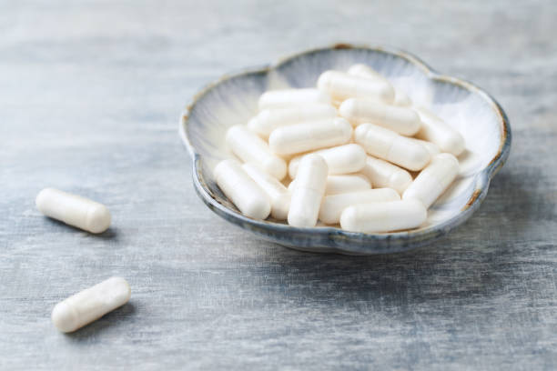 istock Glycine capsules. Concept for a healthy dietary supplementation. Nervous System Support. Bright wooden background. Close up. Copy space. 1168768266