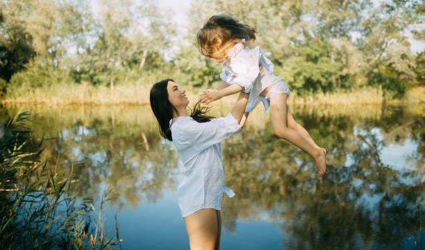 istock Mother and daughter play and have fun over a small river. 1168769862