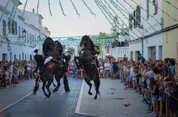 Riders rear up on his horse during a horse celebrations in the Spanish island of Minorca Es Mitjorn Gran, Minorca ,Spain. August 2019: Riders rear up on his horse during a horse celebrations in the Spanish island of Minorca.The horse is the protagonist of all the popular fiestas that the towns of Menorca celebrate in the summer. minorca photos stock pictures, royalty-free photos & images
