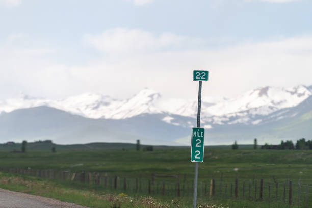Gunnison to snowy Crested Butte mountain on highway road 135 in rural countryside with mile distance sign Gunnison to snowy Crested Butte mountain on highway road 135 in rural countryside with mile distance sign last mile stock pictures, royalty-free photos & images