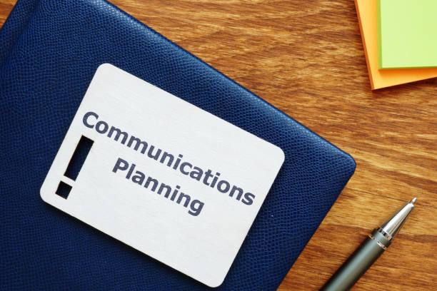 istock Writing note showing Communications Planning.The text is written on a small wooden board with exclamation mark silhouette. There are book, pen, colored papers on the photo. 1168771508