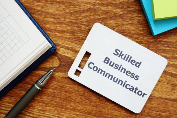 istock Text sign showing Skilled Business Communicator. The text is written on a small wooden board with exclamation mark silhouette. There are notebook, pen, colored papers on the photo. 1168771529