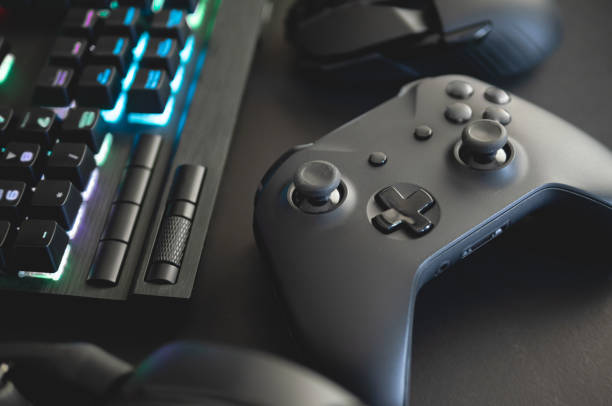 istock e-sport concept with gaming gear, mouse, keyboard, joystick, headset, mobile joystick, in ear headphone and mouse pad on black table background. 1168771558
