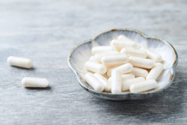 istock Glycine capsules. Concept for a healthy dietary supplementation. Nervous System Support. Bright wooden background. Close up. Copy space. 1168772962