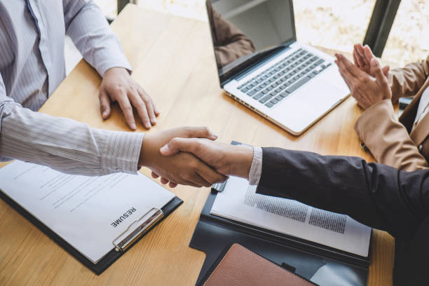 istock Greeting new colleagues, Handshake while job interviewing, male candidate shaking hands with Interviewer or employer after a job interview, employment and recruitment concept 1168773298