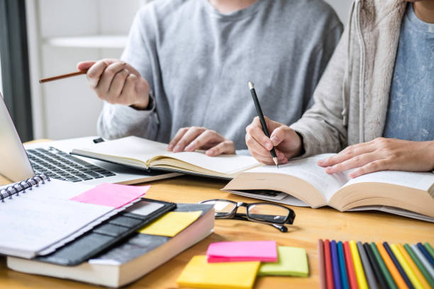 istock High school tutor or college student group sitting at desk in library studying and reading, doing homework and lesson practice preparing exam to entrance, education, teaching, learning concept 1168773518