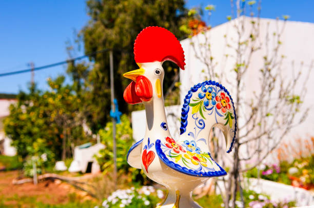 Colourful ceramic cockerel, the Portuguese national symbol, in a cottage garden, Portugal. Colourful ceramic cockerel, the Portuguese national symbol, in a cottage garden, Portugal. alte algarve stock pictures, royalty-free photos & images