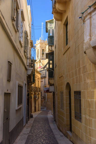 il campanile della chiesa appare sopra gli stretti vicoli del centro storico di victoria, gozo, malta. - rabat gozo foto e immagini stock