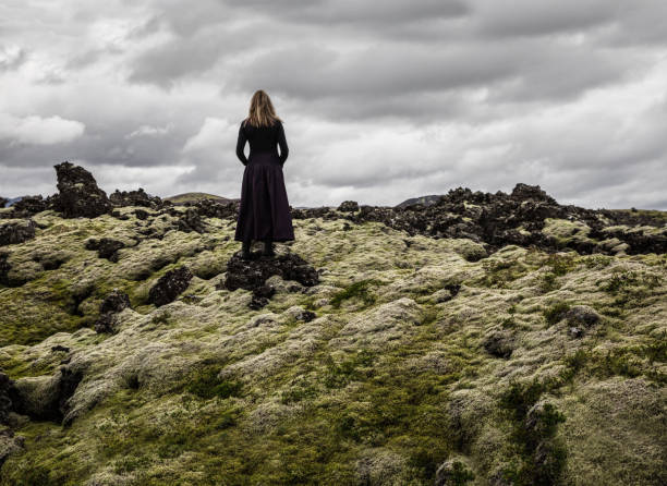 istock Lonely woman walking on mossy lavafield 1168777623