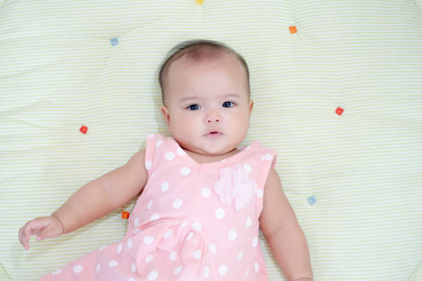 istock Asian baby girl lying down on green background 1168778112