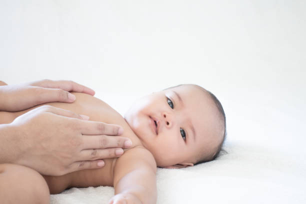 mother hands touching baby with love and care, asian baby girl after shower on the white background - thai ethnicity massaging thailand thai culture imagens e fotografias de stock