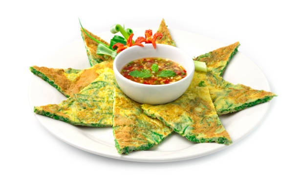 istock Fried Eggs with Climbing Wattle Triangles shape (Acasia Pennata Omelette) Thai food style inside dish with decorate carved vegetables, chili peppers, spring onion with chili spicy sauce dipping side view 1168779157