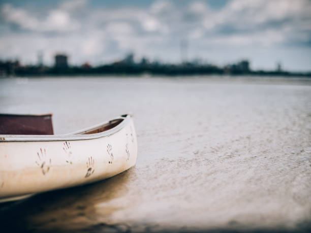 City panorama of downtown Toronto, view off the Lake Ontario. Wooden canoes pared on the shore in the foreground. Selective focus achieved with tilt and shift lens, applying maximum amount of tilt.