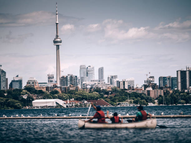 City panorama of downtown Toronto, view off the Lake Ontario. Wooden canoes pared on the shore in the foreground.