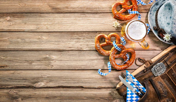 Background for Beer Fest Background for Beer Fest with Bavarian Lederhosen, hat, edelweiss, silverware, pretzels and beer stein on wooden tableHallo bavaria stock pictures, royalty-free photos & images