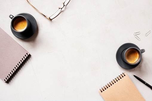 Office background with two cups of coffee espresso and open notepads, concept of morning business meeting, copy space