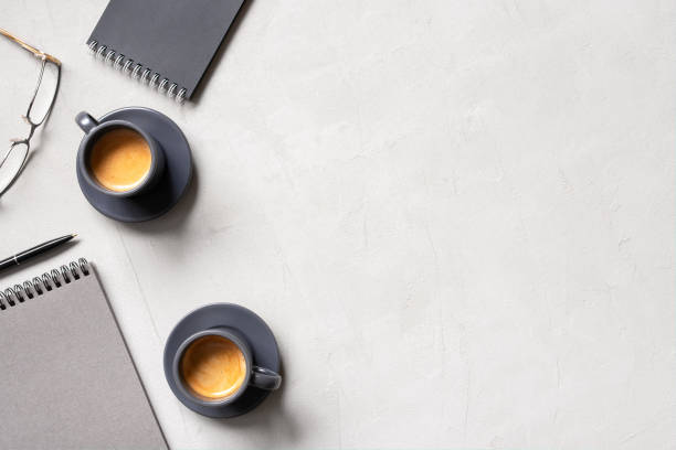 sfondo ufficio con due tazze di caffè espresso e blocchi note aperti - morning coffee coffee cup two objects foto e immagini stock
