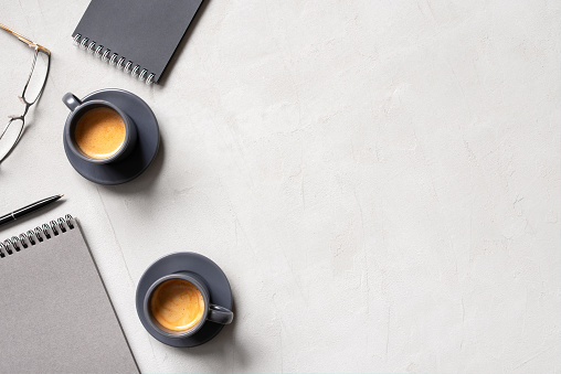 Office background with two cups of coffee espresso and open notepads, concept of morning business meeting, copy space