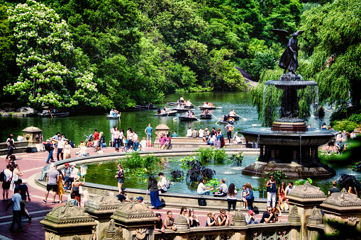 Crowds of people are seen near and around the historic Bethesda Fountain on a summer afternoon, Central Park, Manhattan, New York City.USA ... Bethesda Fountain was built in 1873 and represents purity, health, temperance and peace with Bethesda, the Angel of The Waters on top.