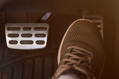 Pressing accelerator car pedal with shoe close-up view