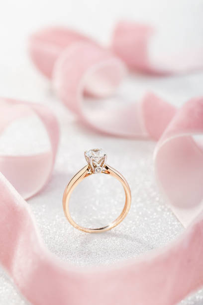 istock Wedding diamond ring on pastel background with pink ribbon 1168790686