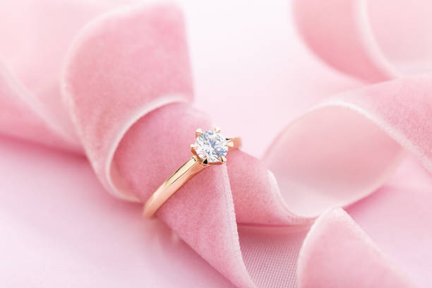 Wedding diamond ring on pastel background with pink ribbon stock photo