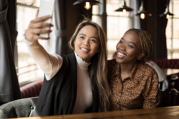 istock Two happy young women taking a selfie in a bar 1168793585