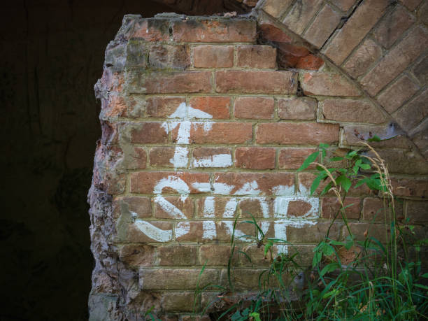 istock White stop sign and direction arrow on a ruined brick wall. Graffiti 1168794763