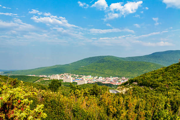 istock A small town among small mountains, forests against a blue sky with olaks. 1168802129