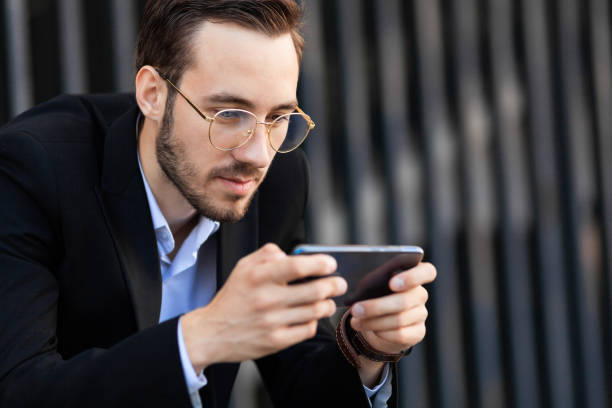istock Modern young man playing on phone, browsing mobile news. Gadget Dependence 1168805795