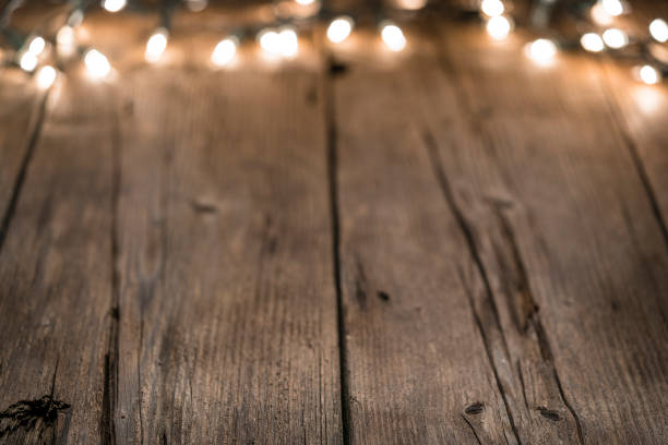 istock Empty rustic wooden table with blurred Christmas lights at background 1168806179