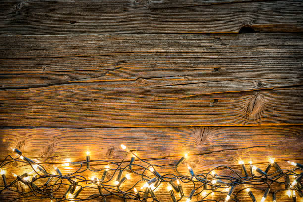 istock Empty rustic wooden table with Christmas lights at the bottom border 1168806184