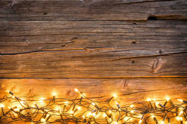 istock Empty rustic wooden table with Christmas lights at the bottom border 1168806185