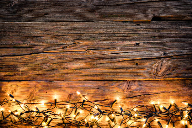 istock Empty rustic wooden table with Christmas lights at the bottom border 1168806186