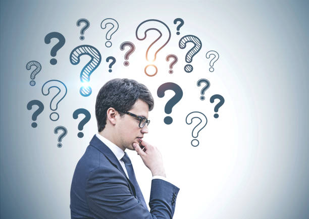 istock Pensive businessman in glasses, question marks 1168806454